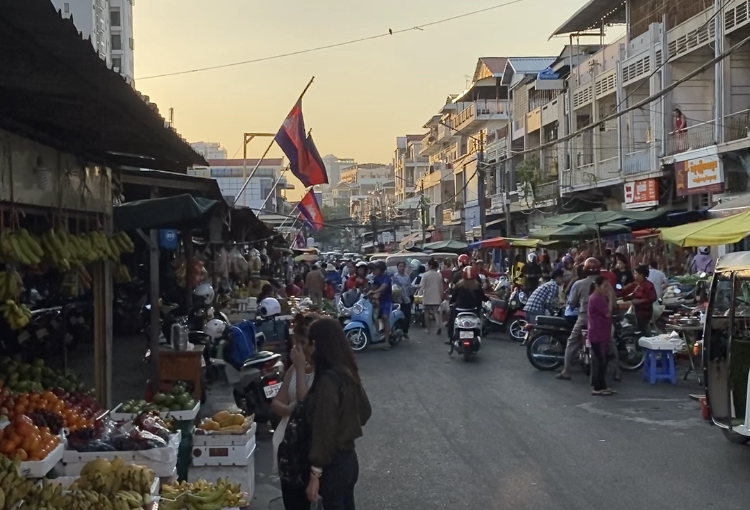Crowded street and waiving flags in Cambodia