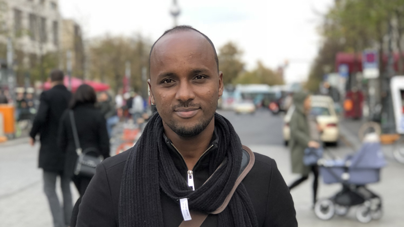 Portrait of Abdifatah Hassan Ali on a crowded street.