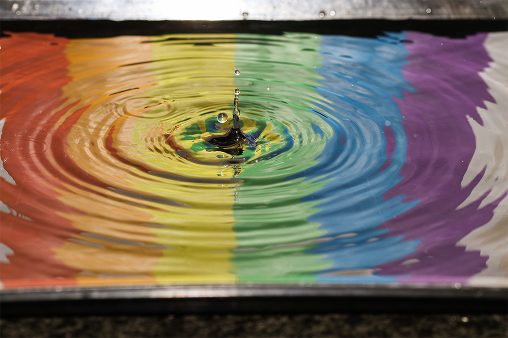 Regnbågsfärger i vattenpöl