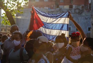 Demonstranter lyfter den kubanska flaggan.