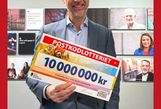 Anders Pettersson tar emot checken från Postkodlotteriet