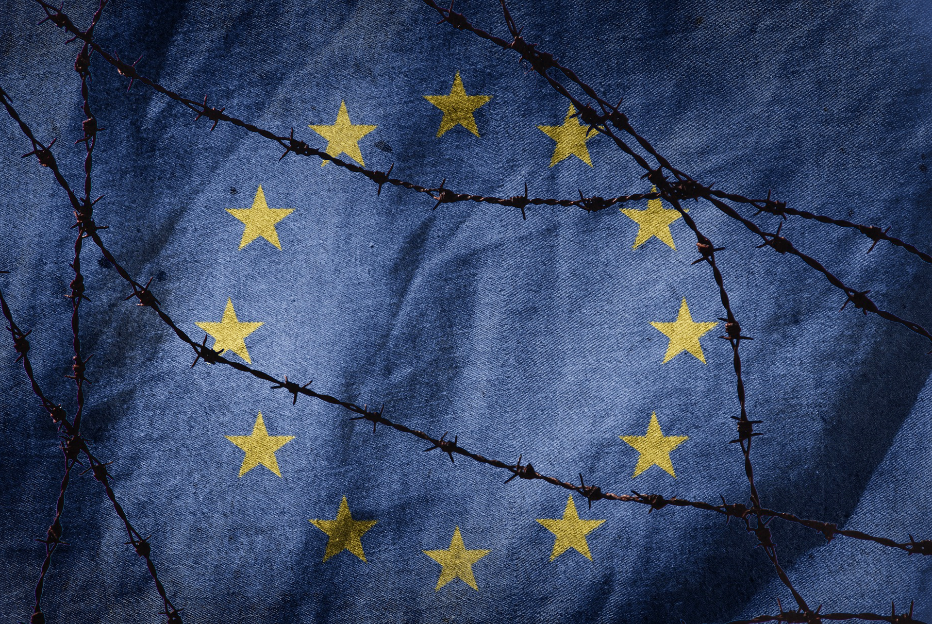 Europeiska unionens flagga täckt med taggtråd