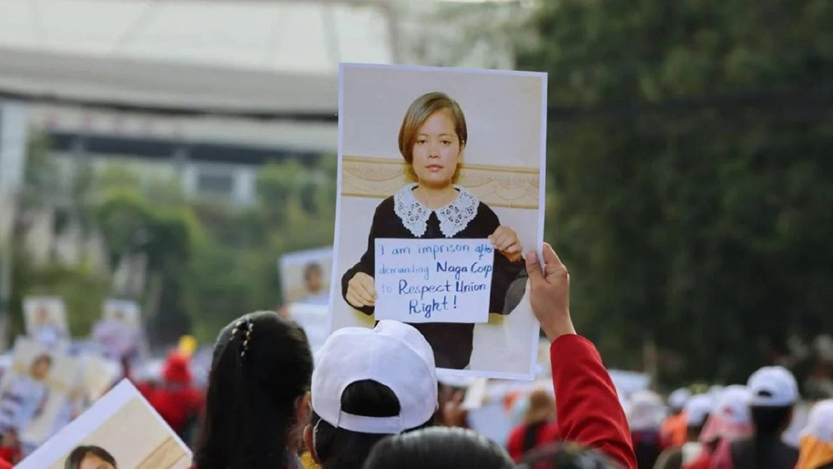 A protester holds up a picture of Sithar Chhim holding up a poster that says, "I am imprisoned after demanding Naga Corp respects Union Rights!"