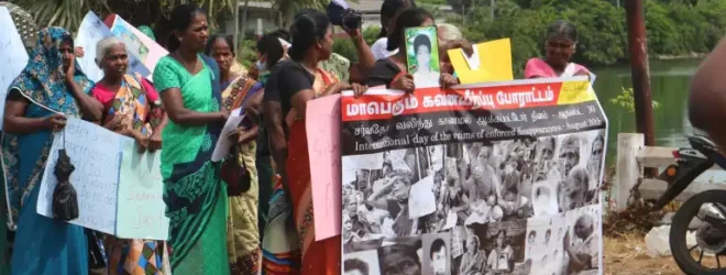 Women in Sri Lanka at a protest march, holding a large banner