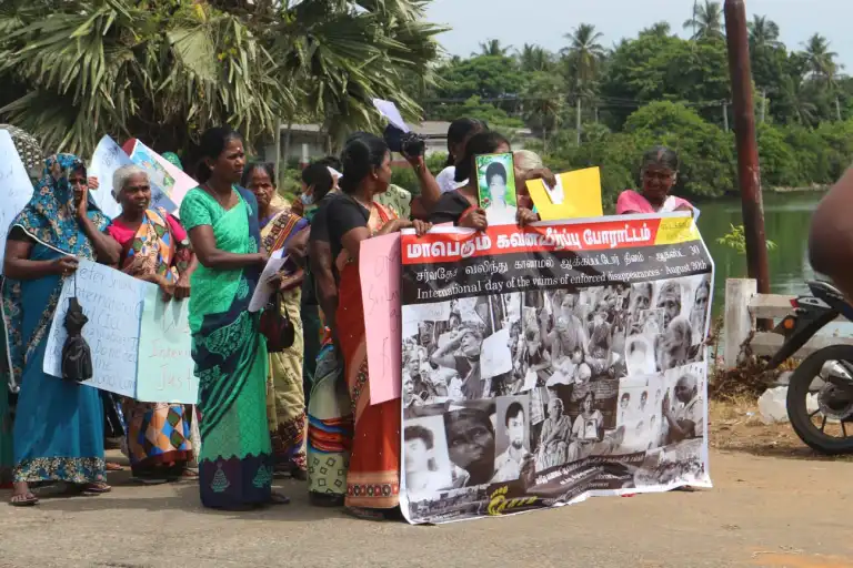 Women in Sri Lanka at a protest march, holding a large banner