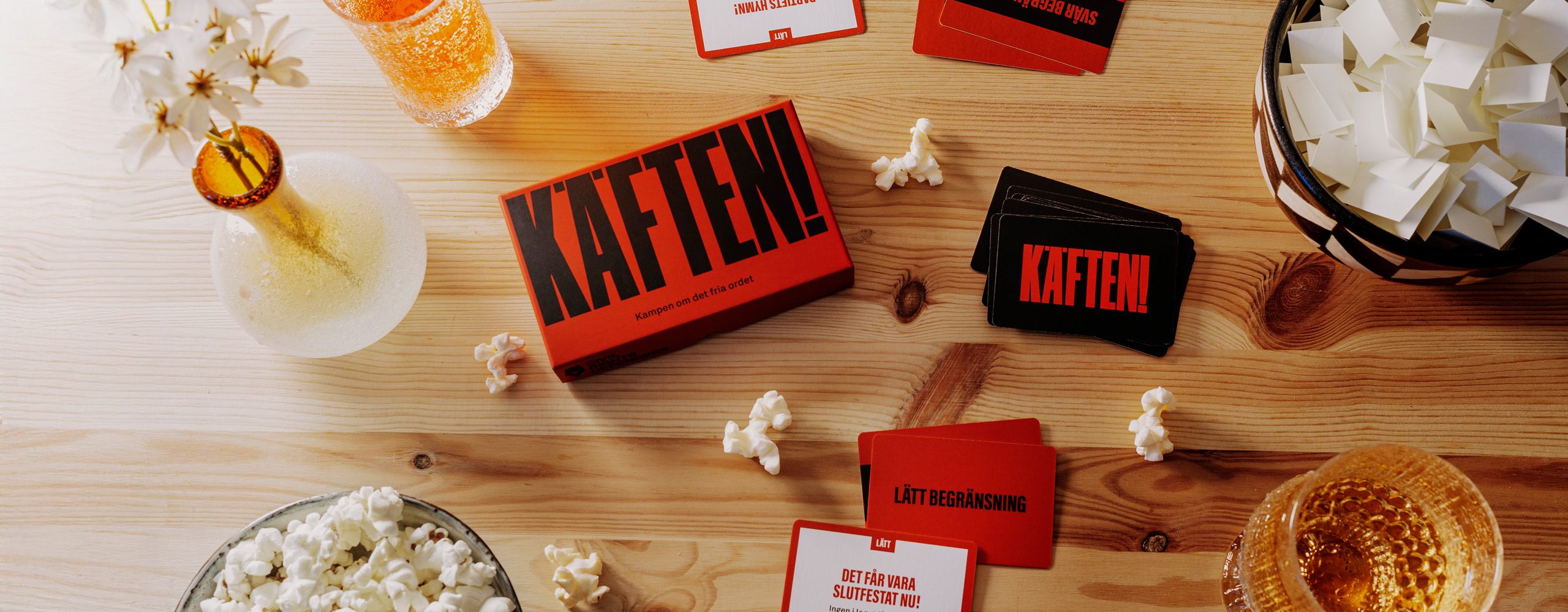 Spelet Käften ligger på ett träbord.