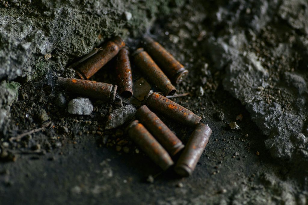 Rusty casings from automatic rifle cartridges on dirty ground