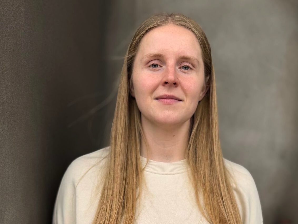 Ung kvinna med lång blont hår och vit tröja