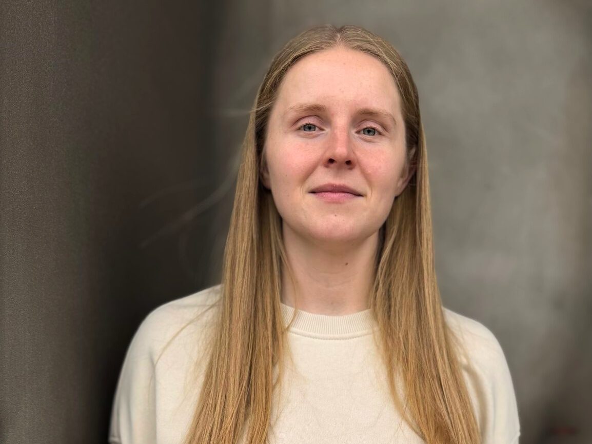 Portrait of woman with long blond hair and a white jumper
