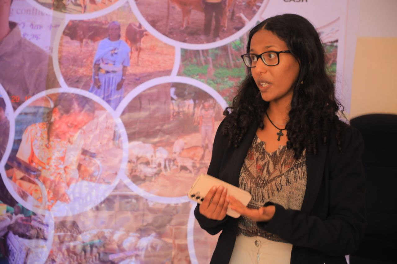 En ung kvinna som står och förklarar någonting på en arbetsplats