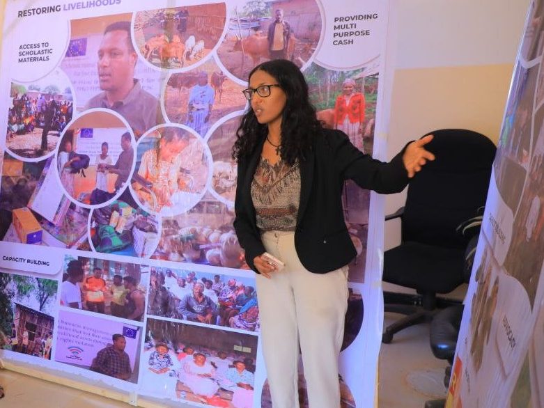 En ung kvinna som pekar på en affisch på en arbetsplats