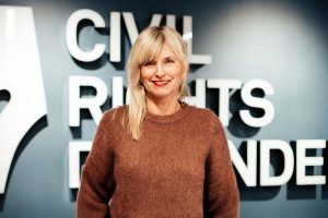 Sofía Walan está de pie frente a una pared con el logotipo de Civil Rights Defenders