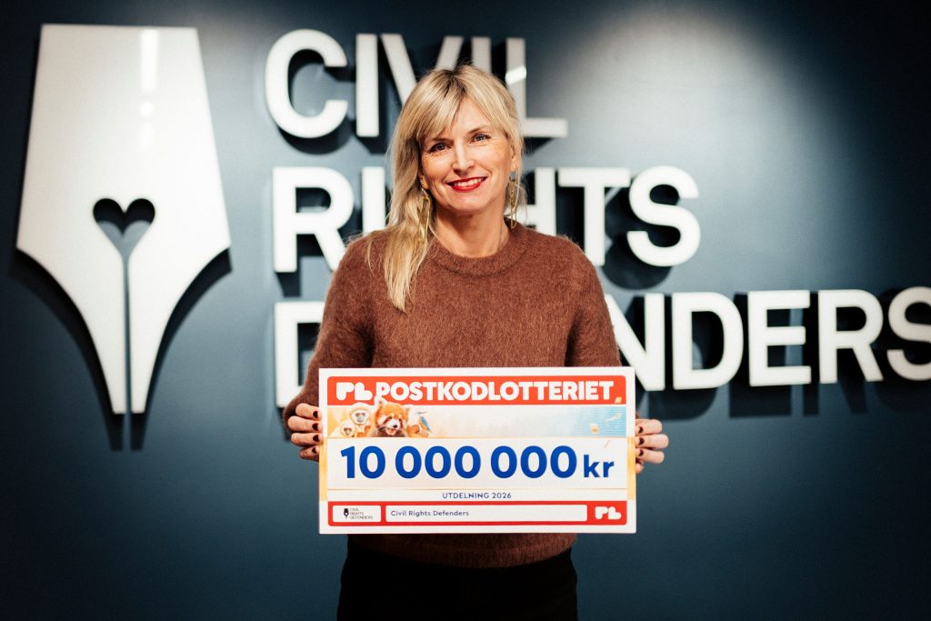 Sofia Walan, generalsekreterare, håller en check från Postkodlotteriets utdelning 2026.