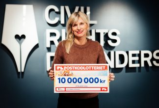 Sofia Walan, generalsekreterare, håller en check från Postkodlotteriets utdelning 2026.