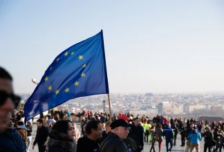 Crowd. Person carrying EU flag.